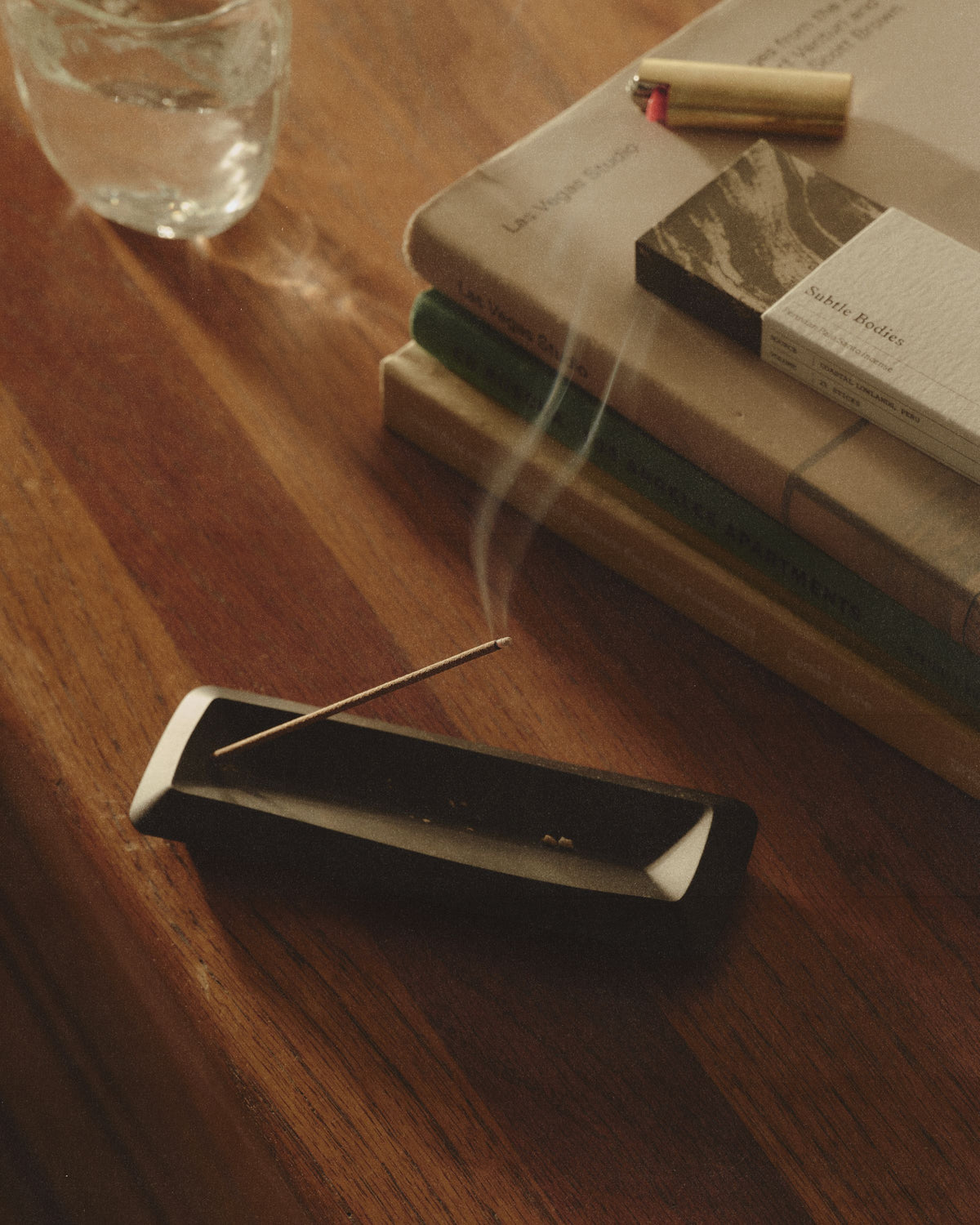 Incense burning in a holder beside books